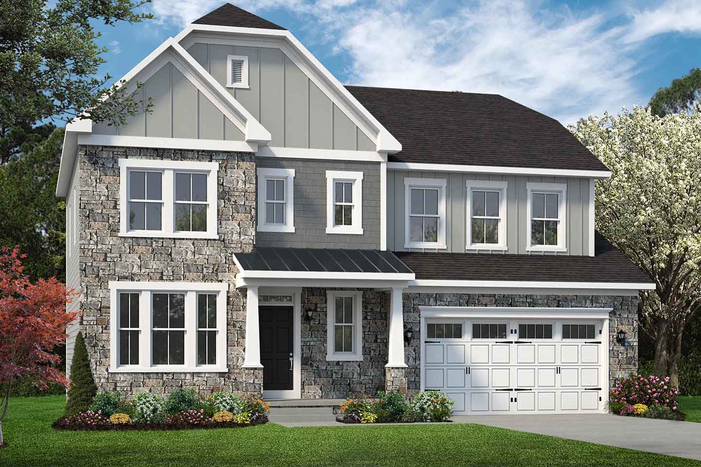 Two-story modern house with stone and gray siding, black roof, and white garage, surrounded by trees and flowers.